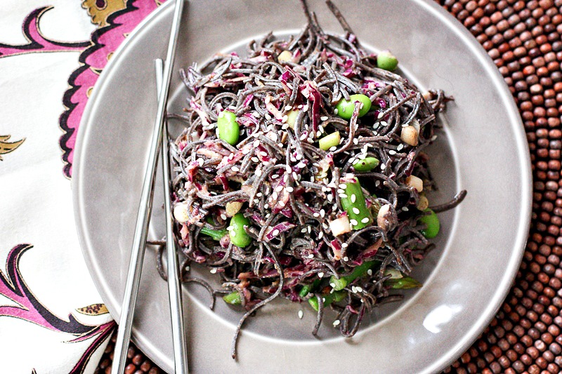 This Asian Sesame Noodle Salad with Almond Butter Dressing is the perfect dish to celebrate spring! It's vegan and gluten-free made with black bean noodles, fresh asparagus and beautiful purple cabbage. #clean #vegan @glutenfree