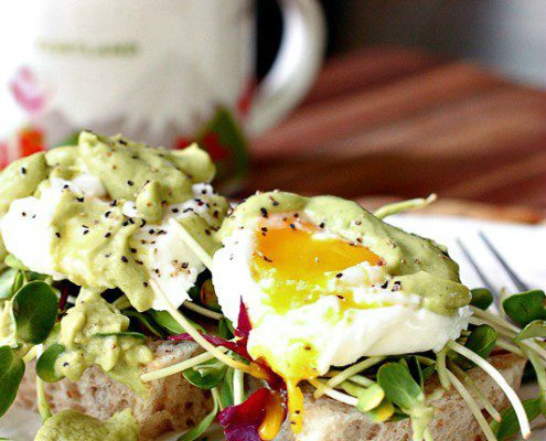 Poached eggs on Sourdough toast with avocado sauce and and microgeens