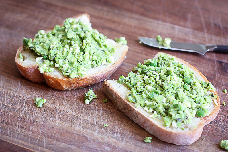 smashed pea toast with feta and mint on sourdough bread